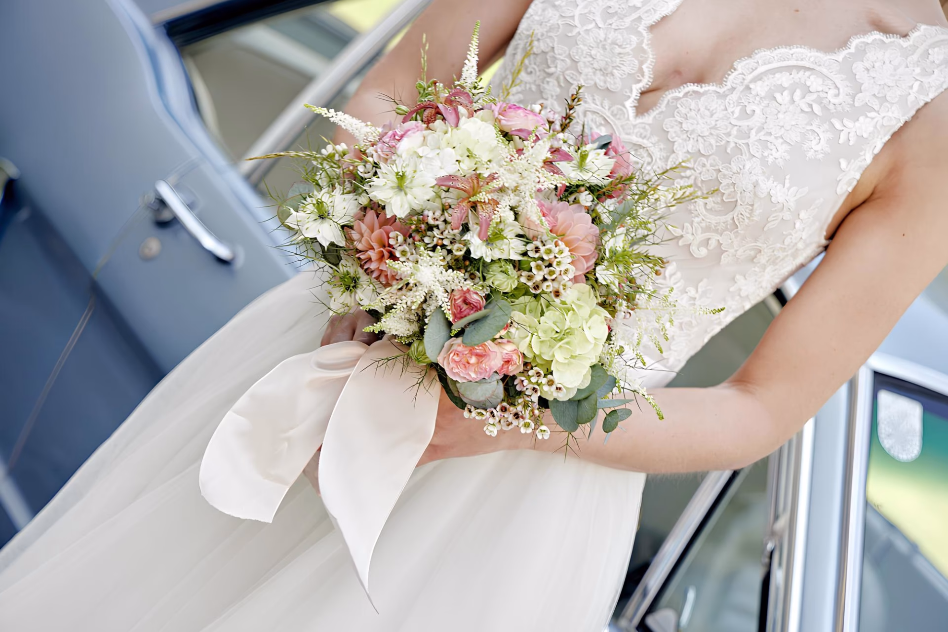 Romantischer Brautstrauß Wien aus rosa Nelken, Wachsblumen und Eukalyptus mit cremefarbener Schleife.
